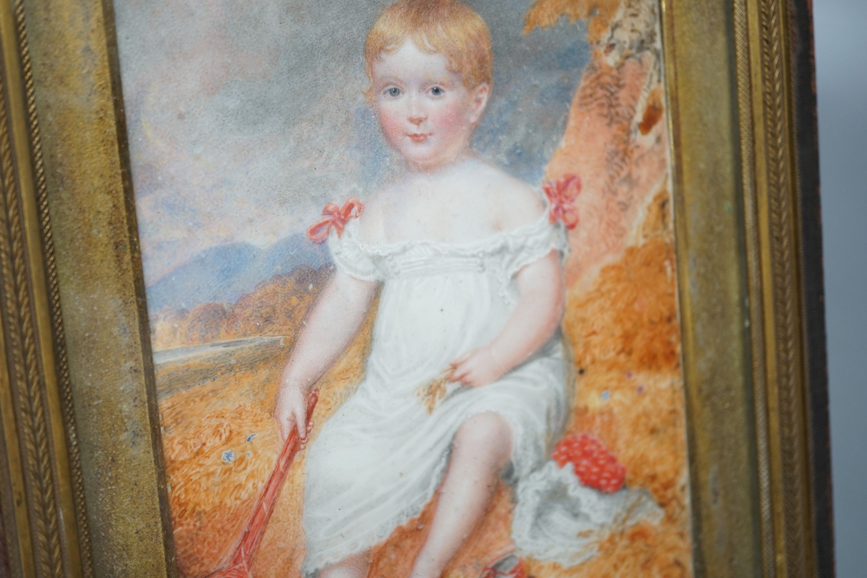 A 19th century portrait miniature on ivory of an infant, with racket and ball, 10 cms wide x 14 cms high.